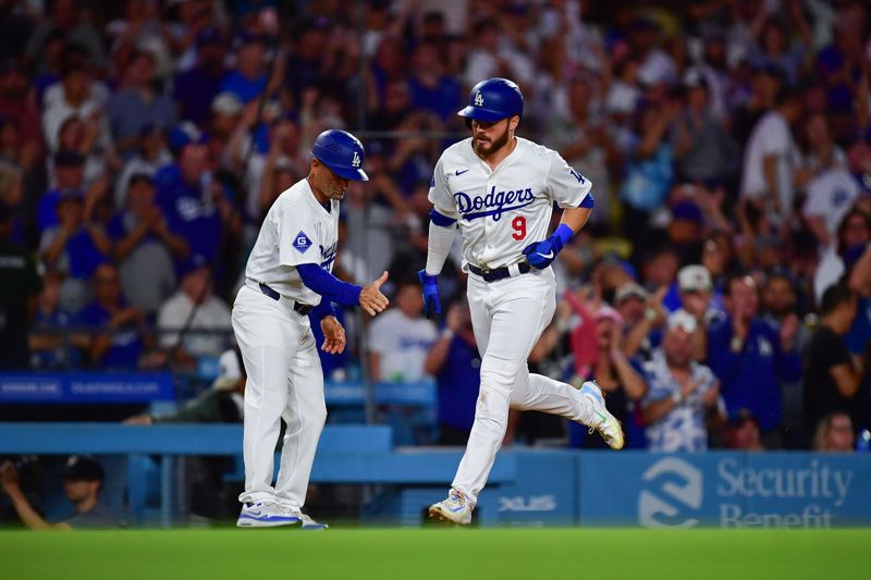 Aug 19, 2024; Los Angeles, California, USA; Los Angeles Dodgers second baseman Gavin Lux (9) is greeted by third base coach Dino Ebel (91) after hitting a solo home run against the Seattle Mariners during the seventh inning at Dodger Stadium. Mandatory Credit: Gary A. Vasquez-USA TODAY Sports