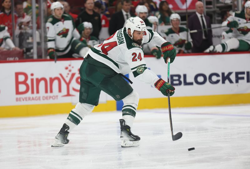 Oct 3, 2025; Chicago, Illinois, USA;  Minnesota Wild defenseman Zach Bogosian (24) clears a puck during the third period against the Chicago Blackhawks at United Center. Mandatory Credit: Talia Sprague-Imagn Images