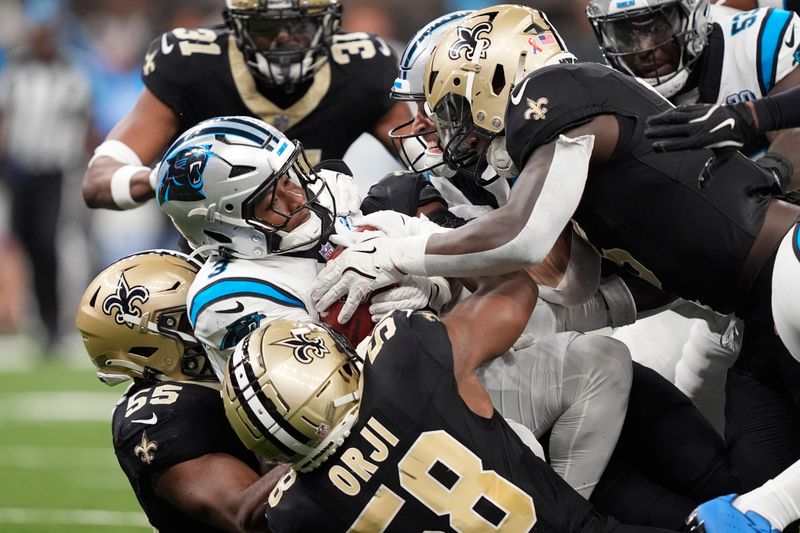 Carolina Panthers running back Raheem Blackshear (3) is tackled by New Orleans Saints defenders during the second half of an NFL football game Sunday, Sept. 8, 2024, in New Orleans. (AP Photo/Gerald Herbert)