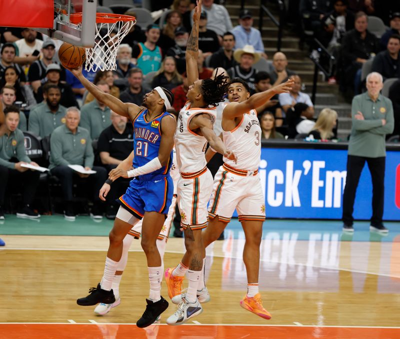 SAN ANTONIO, TX - JANUARY 24:  Aaron Wiggins #21 of the Oklahoma City Thunder drives to the basket against Devin Vassell #24 of the San Antonio Spurs in the second half at Frost Bank Center on January 24, 2024 in San Antonio, Texas. NOTE TO USER: User expressly acknowledges and agrees that, by downloading and or using this photograph, User is consenting to terms and conditions of the Getty Images License Agreement. (Photo by Ronald Cortes/Getty Images)