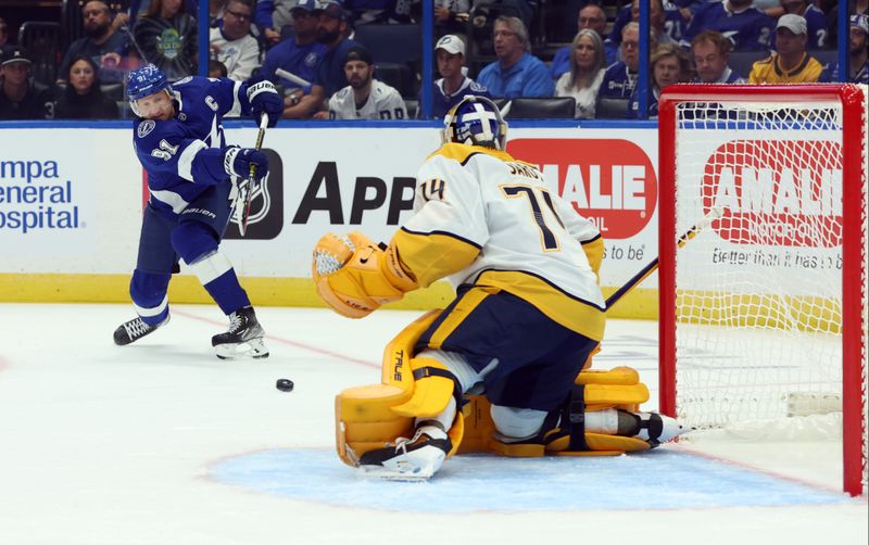 Oct 10, 2023; Tampa, Florida, USA; Tampa Bay Lightning center Steven Stamkos (91) shoots as Nashville Predators goaltender Juuse Saros (74) defends during the first period at Amalie Arena. Mandatory Credit: Kim Klement Neitzel-USA TODAY Sports