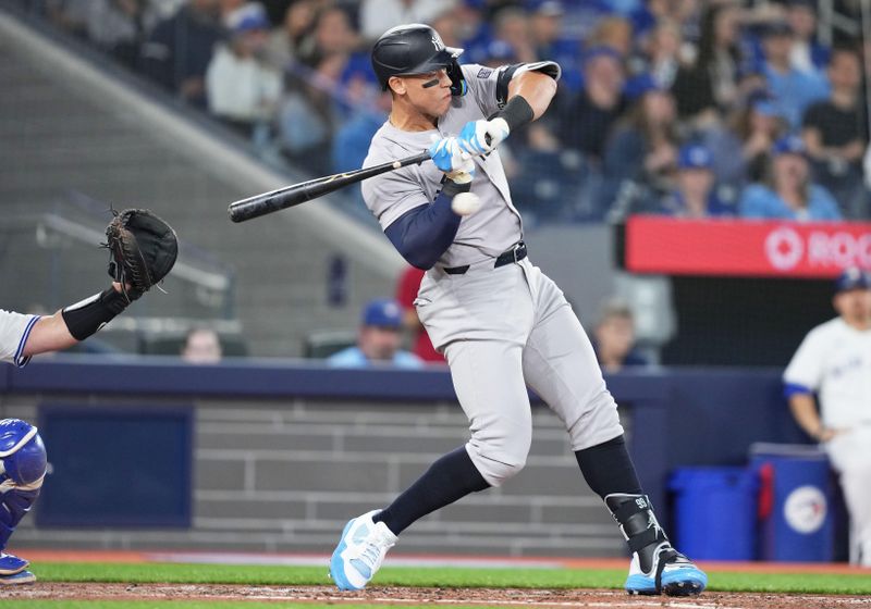 Apr 15, 2024; Toronto, Ontario, CAN; New York Yankees outfielder Aaron Judge wearing number 42 for Jackie Robinson Day gets an inside pitch against the Toronto Blue Jays during the third inning at Rogers Centre. Mandatory Credit: Nick Turchiaro-USA TODAY Sports