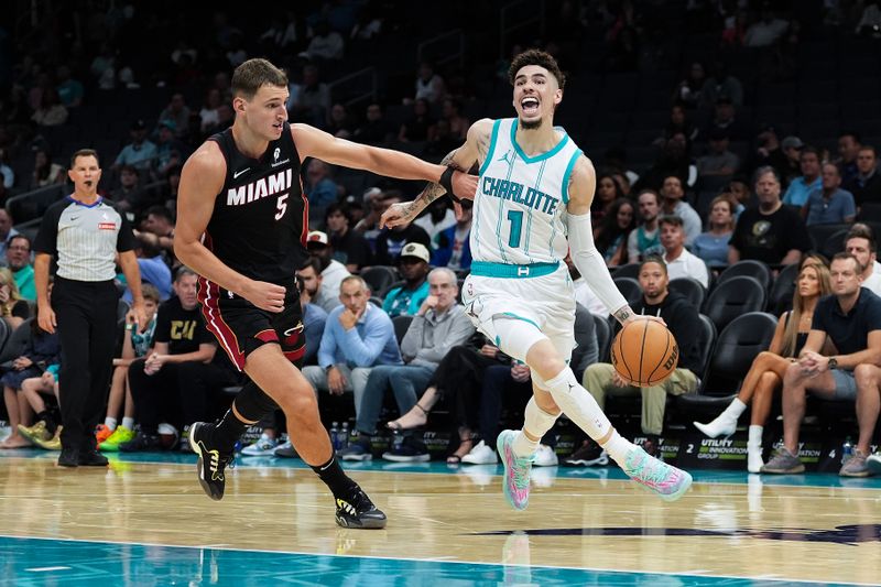 CHARLOTTE, NORTH CAROLINA - OCTOBER 08: LaMelo Ball #1 of the Charlotte Hornets goes to the basket against Nikola Jovic #5 of the Miami Heat during the first half of the preseason game at Spectrum Center on October 08, 2024 in Charlotte, North Carolina. NOTE TO USER: User expressly acknowledges and agrees that, by downloading and or using this photograph, User is consenting to the terms and conditions of the Getty Images License Agreement. (Photo by Grant Halverson/Getty Images)