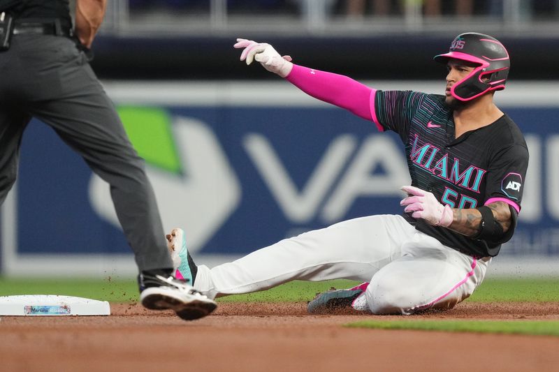 Sep 13, 2025; Miami, Florida, USA;  Miami Marlins designated hitter Agustin Ramirez (50) slides in with a double in the first inning against the Detroit Tigers at loanDepot Park. Mandatory Credit: Jim Rassol-Imagn Images