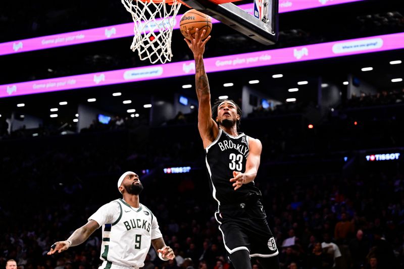 NEW YORK, NEW YORK - DECEMBER 08: Nic Claxton #33 of the Brooklyn Nets attempts a lay up against Bobby Portis #9 of the Milwaukee Bucks during the second half at Barclays Center on December 08, 2024 in New York City. NOTE TO USER: User expressly acknowledges and agrees that, by downloading and or using this Photograph, user is consenting to the terms and conditions of the Getty Images License Agreement. (Photo by Steven Ryan/Getty Images)