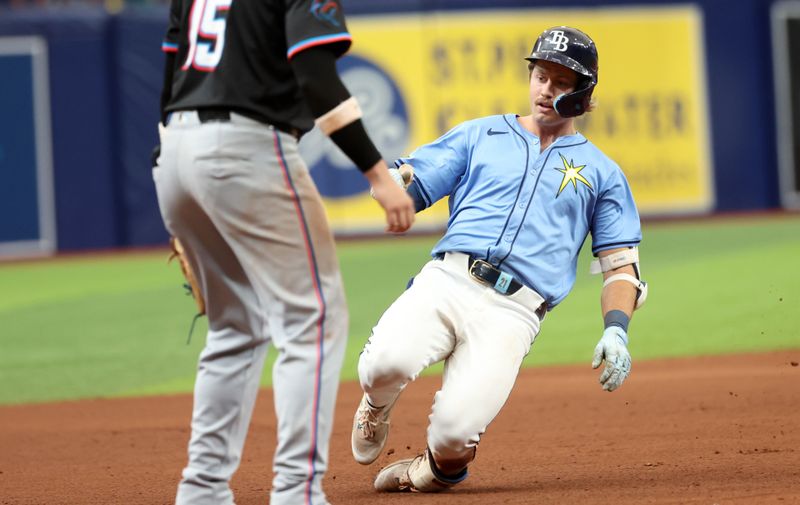 Jul 31, 2024; St. Petersburg, Florida, USA;  Tampa Bay Rays outfielder Jonny DeLuca (21) slides safely into third base with a triple against the Miami Marlins during the seventh inning at Tropicana Field. Mandatory Credit: Kim Klement Neitzel-USA TODAY Sports