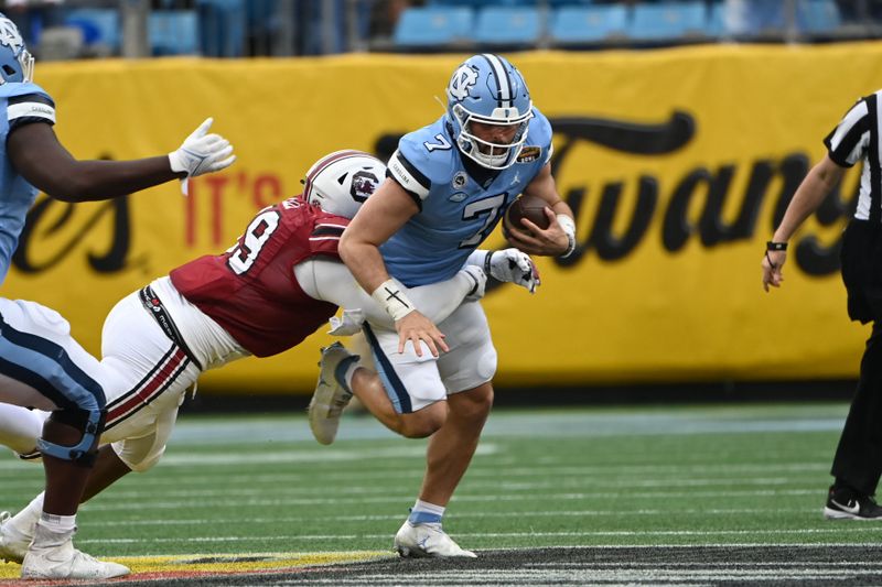 Dec 30, 2021; Charlotte, NC, USA; North Carolina Tar Heels quarterback Sam Howell (7) is sacked by South Carolina Gamecocks defensive lineman Jabari Ellis (99) in the first quarter during the 2021 Duke's Mayo Bowl at Bank of America Stadium. Mandatory Credit: Bob Donnan-USA TODAY Sports