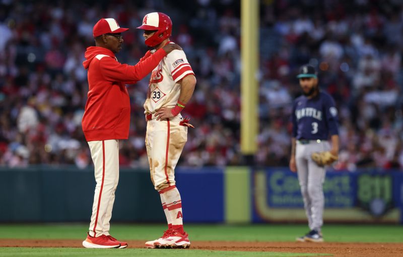 Jun 6, 2025; Anaheim, California, USA; Los Angeles Angels manager Ron Washington (37) talks to outfielder Chris Taylor (33) after he doubled during the fourth inning against the Seattle Mariners at Angel Stadium. Mandatory Credit: Jason Parkhurst-Imagn Images