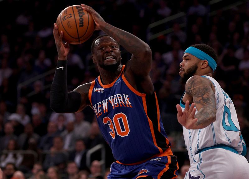 NEW YORK, NEW YORK - NOVEMBER 28:  Julius Randle #30 of the New York Knicks heads for the net as Miles Bridges #0 of the Charlotte Hornets defends during the first half of an NBA In-Season Tournament game at Madison Square Garden on November 28, 2023 in New York City. NOTE TO USER: User expressly acknowledges and agrees that, by downloading and or using this photograph, User is consenting to the terms and conditions of the Getty Images License Agreement. (Photo by Elsa/Getty Images)