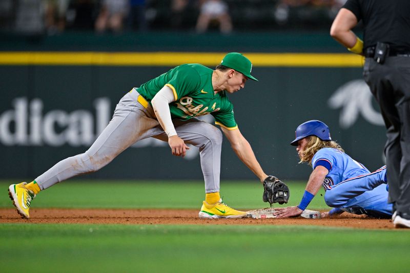 Sep 1, 2024; Arlington, Texas, USA; Texas Rangers right fielder Travis Jankowski (16) slides past the tag of Oakland Athletics second baseman Zack Gelof (20) during the tenth inning at Globe Life Field. Mandatory Credit: Jerome Miron-USA TODAY Sports