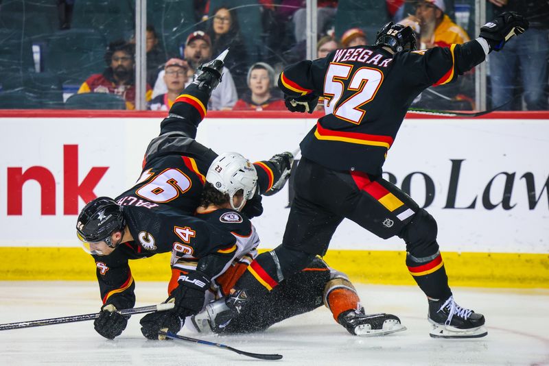 Apr 2, 2024; Calgary, Alberta, CAN; Anaheim Ducks center Mason McTavish (23) collides with Calgary Flames defenseman Brayden Pachal (94) and defenseman MacKenzie Weegar (52) during the second period at Scotiabank Saddledome. Mandatory Credit: Sergei Belski-USA TODAY Sports