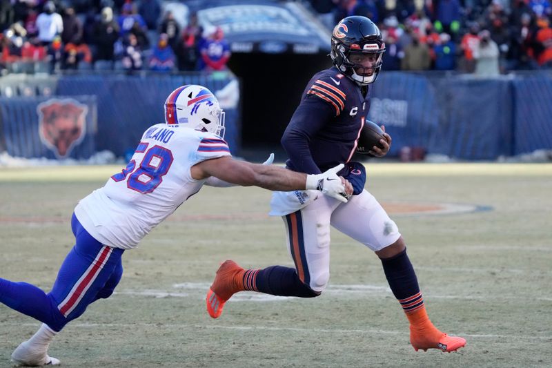 Chicago Bears quarterback Justin Fields, right, runs away from Buffalo Bills linebacker Matt Milano during the second half of an NFL football game, Saturday, Dec. 24, 2022, in Chicago. The Bills won 35-13. (AP Photo/Nam Y. Huh)