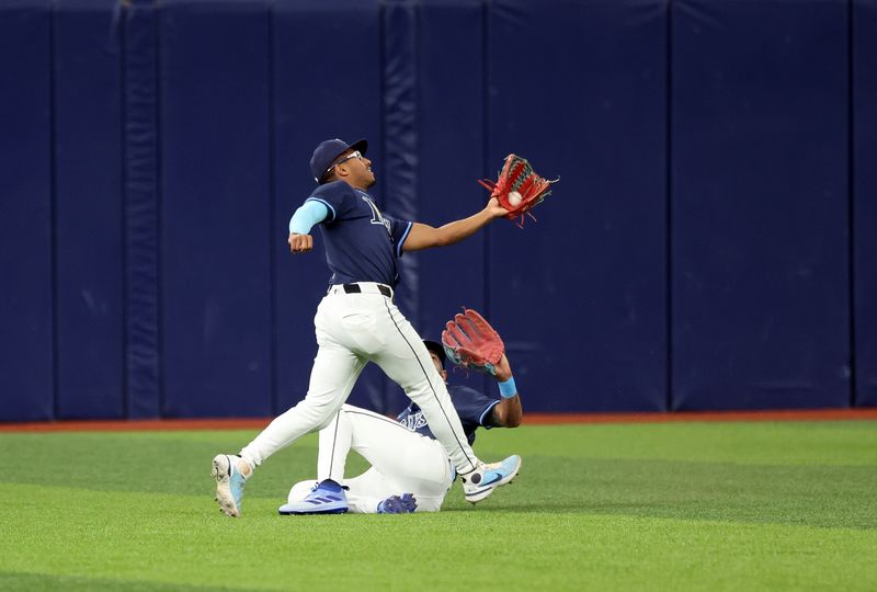 Jun 25, 2024; St. Petersburg, Florida, USA; Tampa Bay Rays outfielder Richie Palacios (1) catches the ball over outfielder Jose Siri (22) against the Seattle Mariners during the first inning  at Tropicana Field. Mandatory Credit: Kim Klement Neitzel-USA TODAY Sports