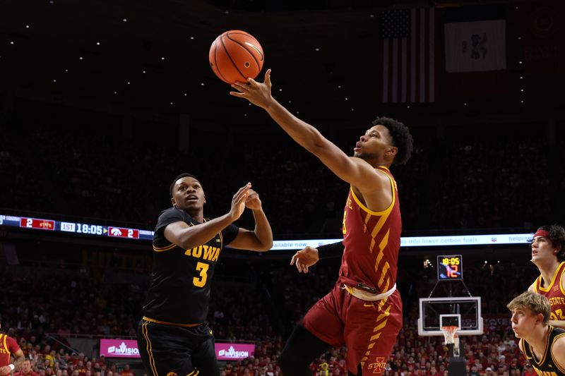 Dec 11, 2025; Ames, Iowa, USA; Iowa State Cyclones forward Joshua Jefferson (5) scores over Iowa Hawkeyes forward Cam Manyawu (3) during the first half at James H. Hilton Coliseum. Mandatory Credit: Reese Strickland-Imagn Images