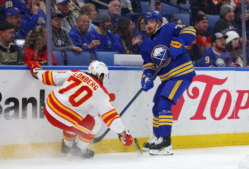 Nov 9, 2024; Buffalo, New York, USA;  Buffalo Sabres defenseman Connor Clifton (75) clears the puck as Calgary Flames left wing Ryan Lomberg (70) tries to block it during the first period at KeyBank Center. Mandatory Credit: Timothy T. Ludwig-Imagn Images