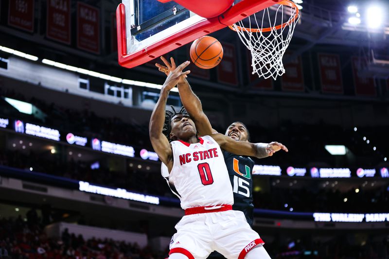 Jan 14, 2023; Raleigh, North Carolina, USA; Miami Hurricanes forward Norchad Omier (15) blocks North Carolina State Wolfpack guard Terquavion Smith (0) dunk during the first half at PNC Arena. Mandatory Credit: Jaylynn Nash-USA TODAY Sports