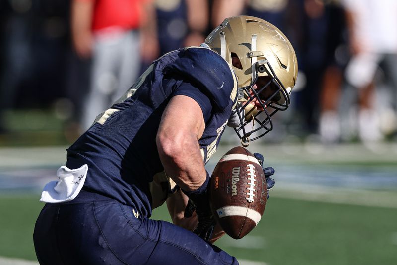 Oct 26, 2024; East Rutherford, New Jersey, USA; Navy Midshipmen running back Eli Heidenreich (22) can not secure a punt during the second half against the Notre Dame Fighting Irish at MetLife Stadium. Mandatory Credit: Vincent Carchietta-Imagn Images