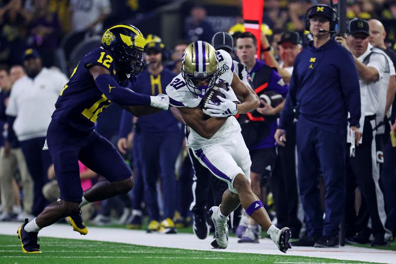 Jan 8, 2024; Houston, TX, USA; Washington Huskies running back Tybo Rogers (20) runs the ball against Michigan Wolverines defensive back Josh Wallace (12) during the first quarter in the 2024 College Football Playoff national championship game at NRG Stadium. Mandatory Credit: Troy Taormina-USA TODAY Sports