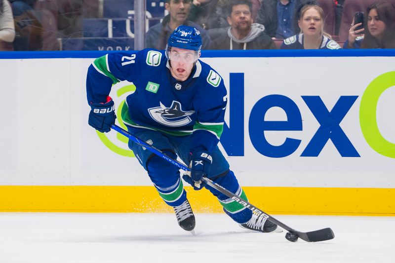 Feb 27, 2024; Vancouver, British Columbia, CAN; Vancouver Canucks forward Nils Hoglander (21) handles the puck against the Pittsburgh Penguins in the third period at Rogers Arena. Penguins won 4-3 in overtime. Mandatory Credit: Bob Frid-USA TODAY Sports