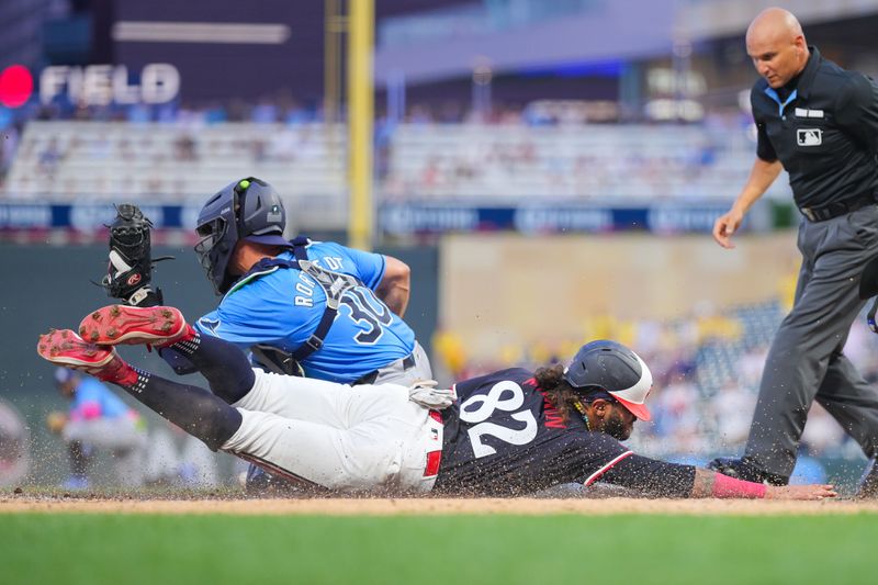 Jun 18, 2024; Minneapolis, Minnesota, USA; Minnesota Twins outfielder Austin Martin (82) slides home against the Tampa Bay Rays catcher Ben Rortvedt (30) in the fourth inning at Target Field. Mandatory Credit: Brad Rempel-USA TODAY Sports