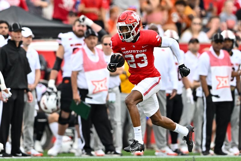 Nov 18, 2023; Houston, Texas, USA; Houston Cougars defensive back Isaiah Hamilton (23) runs his interception to the end zone for a touch down during the first quarter against the Oklahoma State Cowboys at TDECU Stadium. Mandatory Credit: Maria Lysaker-USA TODAY Sports