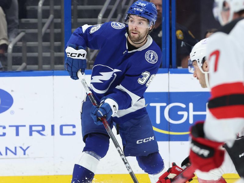 Jan 27, 2024; Tampa, Florida, USA; Tampa Bay Lightning left wing Brandon Hagel (38) passes the puck against the New Jersey Devils during the first period at Amalie Arena. Mandatory Credit: Kim Klement Neitzel-USA TODAY Sports