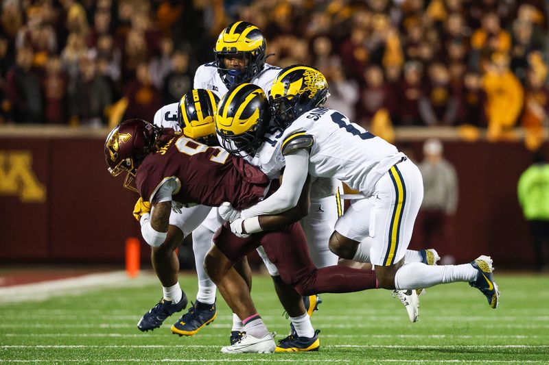 Oct 7, 2023; Minneapolis, Minnesota, USA; Minnesota Golden Gophers wide receiver Daniel Jackson (9) is tackled by a crowd of Michigan Wolverines during the second quarter at Huntington Bank Stadium. Mandatory Credit: Matt Krohn-USA TODAY Sports