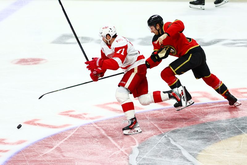 Feb 26, 2026; Ottawa, Ontario, CAN; Detroit Red Wings center Dylan Larkin (71) and Ottawa Senators defenseman Jake Sanderson (85) chase the puck during the third period at Canadian Tire Centre. Mandatory Credit: Keito Newman-Imagn Images