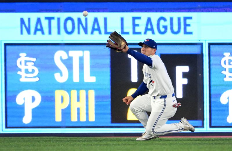 May 14, 2025; Toronto, Ontario, CAN;  Toronto Blue Jays center fielder Daulton Varsho (5) catches a fly ball hit by Tampa Bay Rays right fielder Taylor Walls (not shown) inning at Rogers Centre. Mandatory Credit: Dan Hamilton-Imagn Images