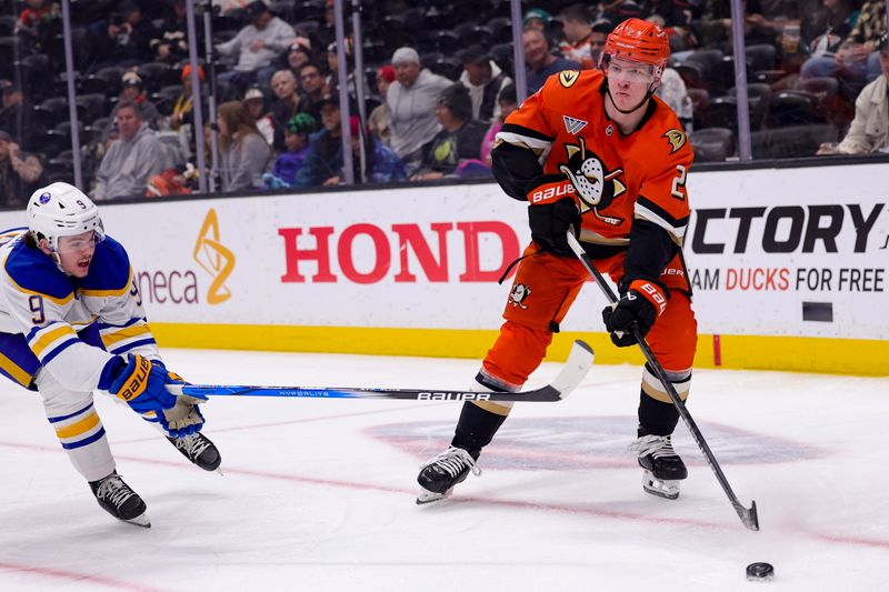 Nov 22, 2024; Anaheim, California, USA; Anaheim Ducks defenseman Jackson LaCombe (2) passes the puck ahead of Buffalo Sabres left wing Zach Benson (9) during the first period at Honda Center. Mandatory Credit: Ryan Sun-Imagn Images