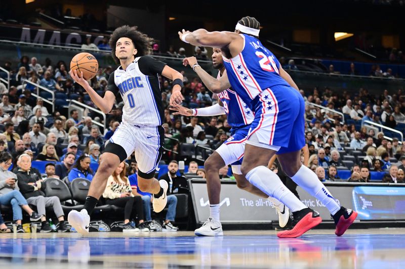 ORLANDO, FLORIDA - OCTOBER 18: Anthony Black #0 of the Orlando Magic drives to the net against Justin Edwards #19 and Guerschon Yabusele #28 of the Philadelphia 76ers in the second half of a game at Kia Center on October 18, 2024 in Orlando, Florida. NOTE TO USER: User expressly acknowledges and agrees that, by downloading and or using this photograph, User is consenting to the terms and conditions of the Getty Images License Agreement. (Photo by Julio Aguilar/Getty Images)