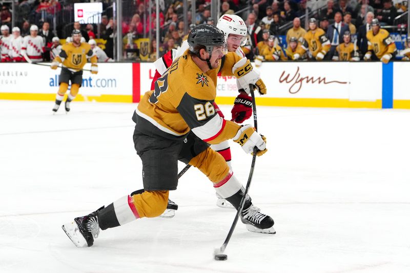 Nov 11, 2024; Las Vegas, Nevada, USA; Vegas Golden Knights right wing Alexander Holtz (26) shoots against the Carolina Hurricanes during the second period at T-Mobile Arena. Mandatory Credit: Stephen R. Sylvanie-Imagn Images