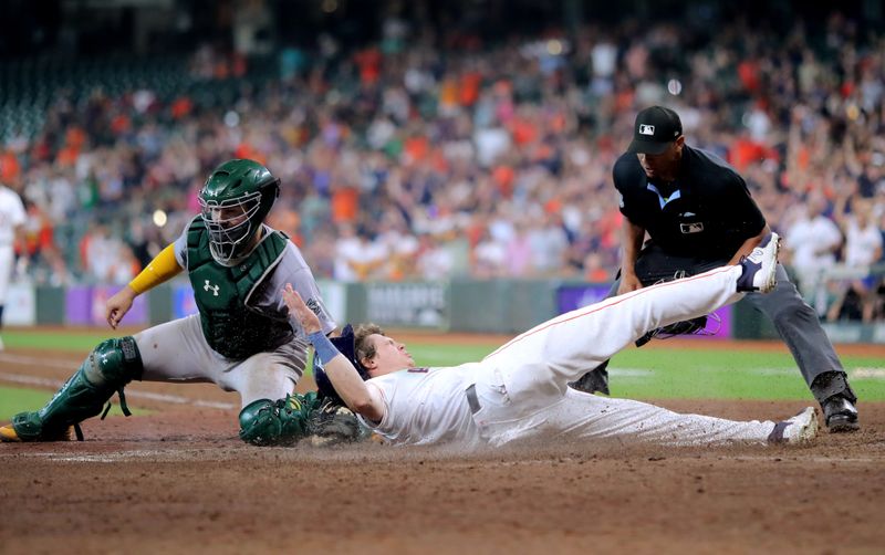 Sep 12, 2024; Houston, Texas, USA; Houston Astros center fielder Jake Meyers (6) slides into home plate while beating the tag of Oakland Athletics catcher Shea Langeliers (23) to score a run against the Oakland Athletics during the eighth inning at Minute Maid Park. Mandatory Credit: Erik Williams-Imagn Images