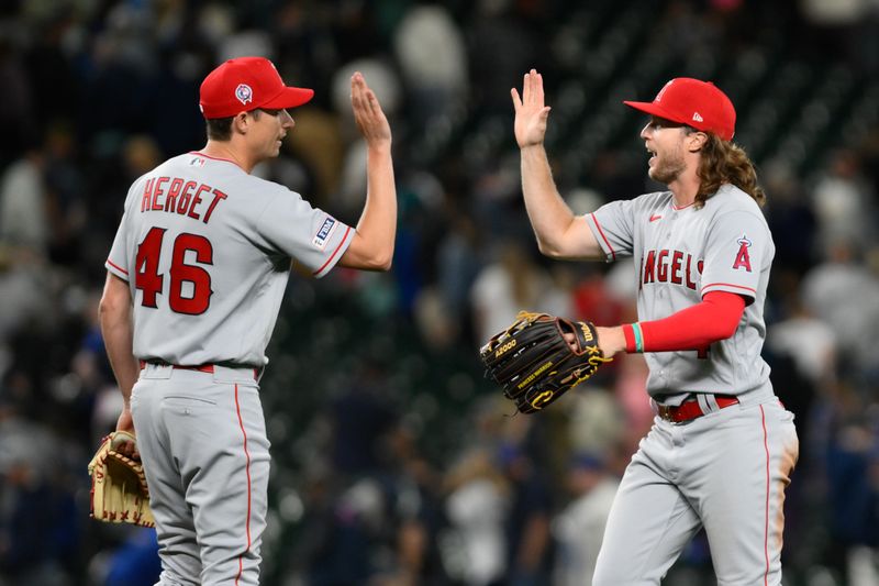 Sep 11, 2023; Seattle, Washington, USA; Los Angeles Angels relief pitcher Jimmy Herget (46) and center fielder Brett Phillips (4) celebrate defeating the Seattle Mariners at T-Mobile Park. Mandatory Credit: Steven Bisig-USA TODAY Sports