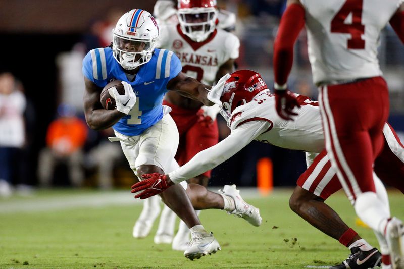 Oct 7, 2023; Oxford, Mississippi, USA; Mississippi Rebels running back Quinshon Judkins (4) runs the ball as Arkansas Razorbacks defensive back Jayden Johnson (8) makes the tackle during the second half at Vaught-Hemingway Stadium. Mandatory Credit: Petre Thomas-USA TODAY Sports