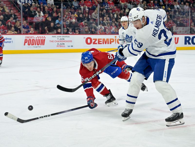 Apr 6, 2024; Montreal, Quebec, CAN; Toronto Maple Leafs forward Pontus Holmberg (29) plays the puck and Montreal Canadiens defenseman Jordan Harris (54) defends during the first period at the Bell Centre. Mandatory Credit: Eric Bolte-USA TODAY Sports