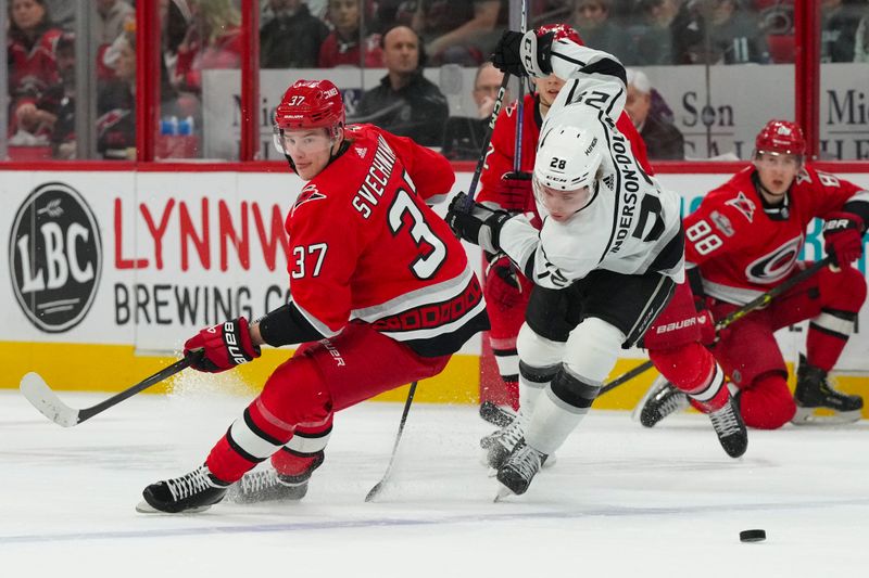 Jan 31, 2023; Raleigh, North Carolina, USA; Carolina Hurricanes right wing Andrei Svechnikov (37) and Los Angeles Kings center Jaret Anderson-Dolan (28) look at the puck during the first period at PNC Arena. Mandatory Credit: James Guillory-USA TODAY Sports