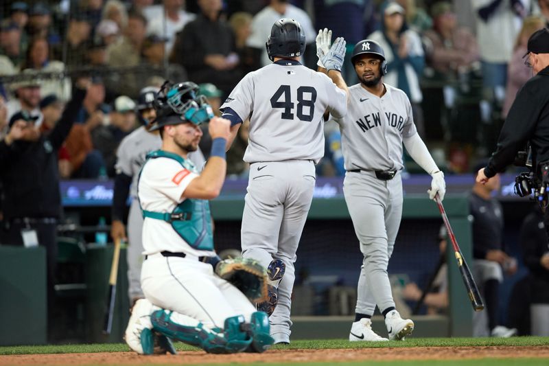 May 14, 2025; Seattle, Washington, USA; New York Yankees first base Paul Goldschmidt (48) is congratulated by New York Yankees third baseman Jorbit Vivas (90) on his solo home run with Seattle Mariners catcher Cal Raleigh (29) in the front during the seventh inning at T-Mobile Park. Mandatory Credit: John Froschauer-Imagn Images