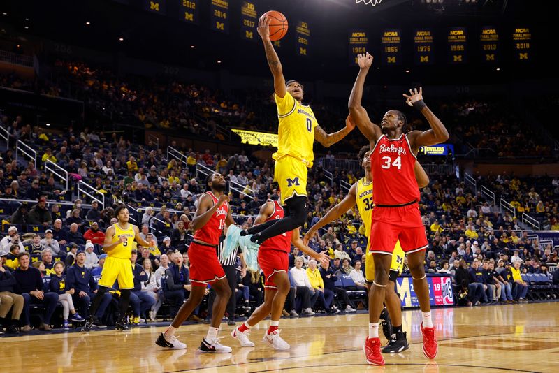 Jan 15, 2024; Ann Arbor, Michigan, USA; Michigan Wolverines guard Dug McDaniel (0) shoots as Ohio State Buckeyes center Felix Okpara (34) defends in the first half at Crisler Center. Mandatory Credit: Rick Osentoski-USA TODAY Sports