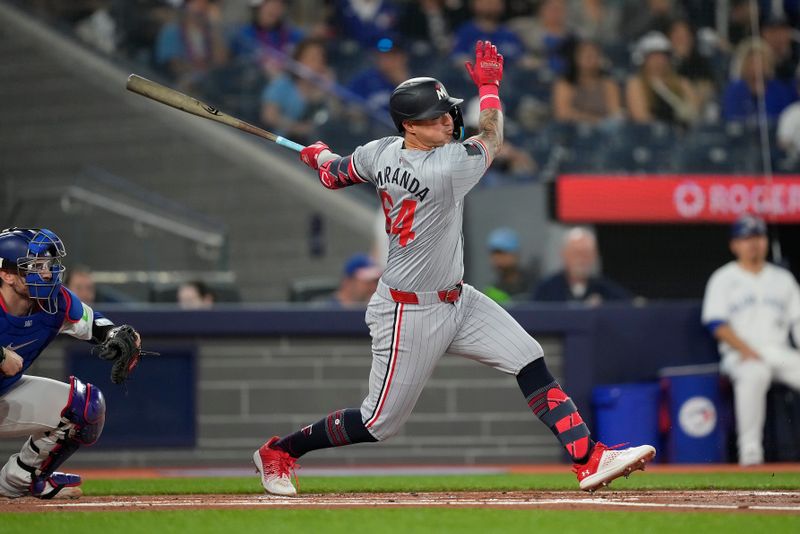 May 10, 2024; Toronto, Ontario, CAN; Minnesota Twins third baseman Jose Miranda (64) hits a one-run single against the Toronto Blue Jays during the first inning at Rogers Centre. Mandatory Credit: John E. Sokolowski-USA TODAY Sports