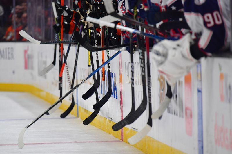 Feb 21, 2024; Anaheim, California, USA; Anaheim Ducks and Columbus Blue Jackets players hit their sticks on the boards as right wing Mathieu Olivier (24) and left wing Ross Johnston (44) fight during the second period at Honda Center. Mandatory Credit: Gary A. Vasquez-USA TODAY Sports