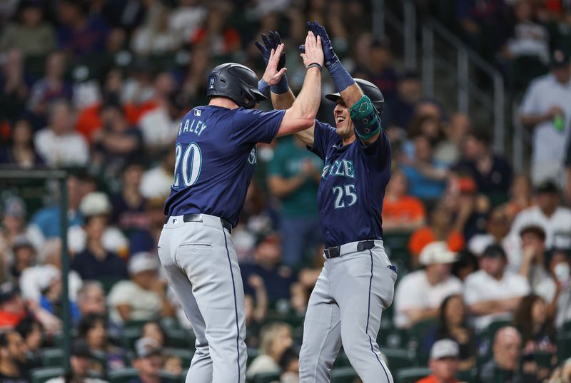 May 3, 2024; Houston, Texas, USA; Seattle Mariners shortstop Dylan Moore (25) celebrates with left fielder Luke Raley (20) after hitting a home run during the fifth inning against the Houston Astros at Minute Maid Park. Mandatory Credit: Troy Taormina-USA TODAY Sports