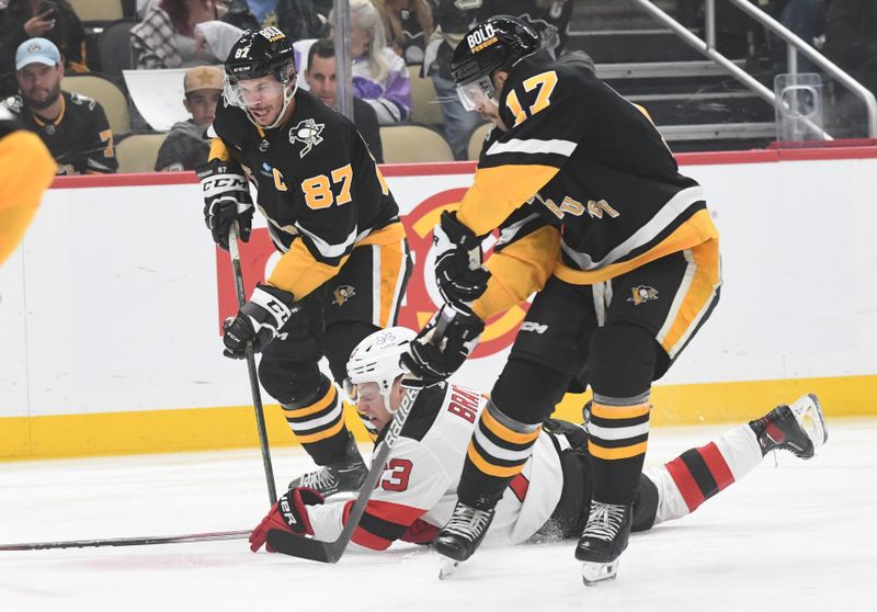 Nov 16, 2023; Pittsburgh, Pennsylvania, USA; Pittsburgh Penguins center Sidney Crosby (87) and right wing Bryan Rust (17) skate around New Jersey Devils left wing Jesper Bratt (63) during the first period at PPG Paints Arena. Mandatory Credit: Philip G. Pavely-USA TODAY Sports