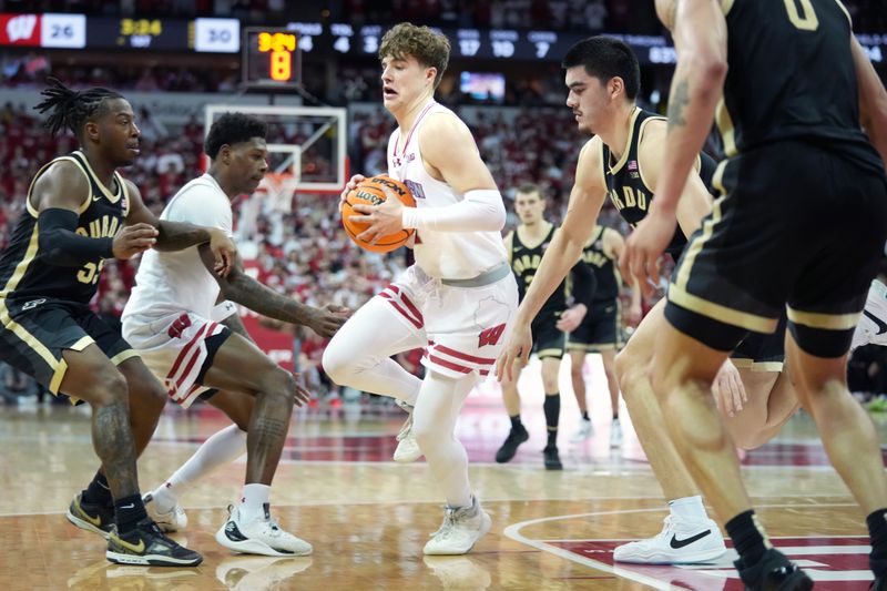 Feb 4, 2024; Madison, Wisconsin, USA; Wisconsin Badgers guard Max Klesmit (11) intercepts a pass intended for Purdue Boilermakers center Zach Edey (15) during the first half at the Kohl Center. Mandatory Credit: Kayla Wolf-USA TODAY Sports