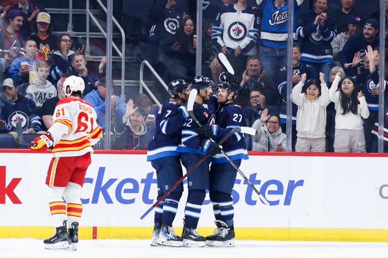 Oct 2, 2024; Winnipeg, Manitoba, CAN;  Winnipeg Jets forward Nino Niederreiter (62) is congratulated by his team mates on his goal against  Calgary Flames goalie Dustin Wolf (32) during the first period at Canada Life Centre. Mandatory Credit: Terrence Lee-Imagn Images