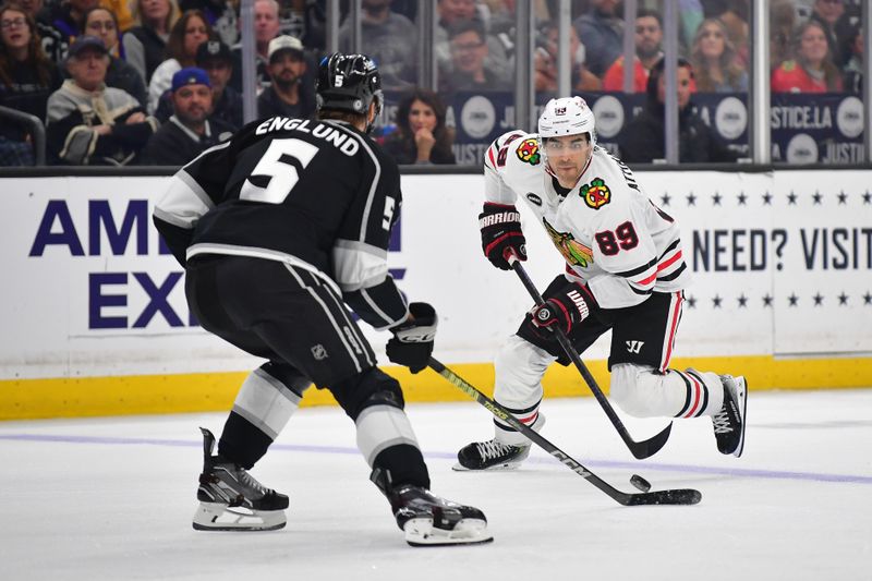 Apr 18, 2024; Los Angeles, California, USA; Chicago Blackhawks center Andreas Athanasiou (89) moves the puck against Los Angeles Kings defenseman Andreas Englund (5) during the third period at Crypto.com Arena. Mandatory Credit: Gary A. Vasquez-USA TODAY Sports