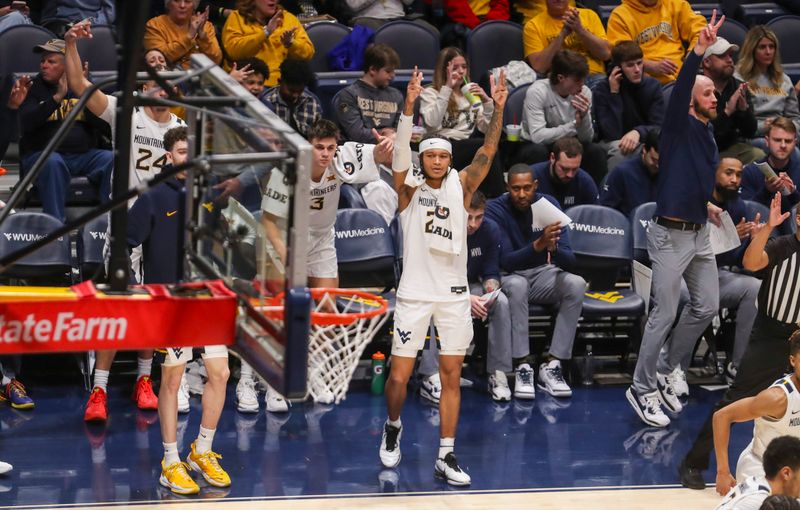 Feb 20, 2024; Morgantown, West Virginia, USA; West Virginia Mountaineers guard RaeQuan Battle (21) celebrates from the bench after a score during the second half against the UCF Knights at WVU Coliseum. Mandatory Credit: Ben Queen-USA TODAY Sports