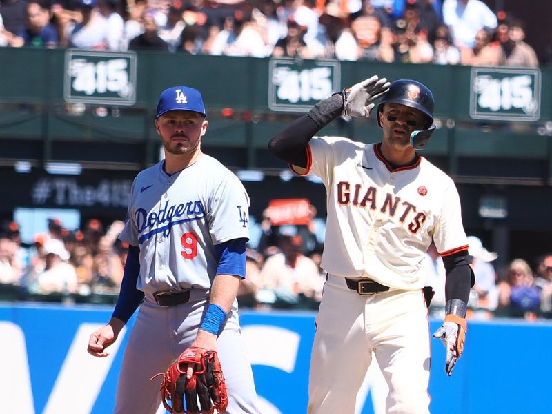 Jun 30, 2024; San Francisco, California, USA; San Francisco Giants shortstop Nick Ahmed (16) salutes b behind Los Angeles Dodgers second baseman Gavin Lux (9) after hitting a double during the seventh inning at Oracle Park. Mandatory Credit: Kelley L Cox-USA TODAY Sports