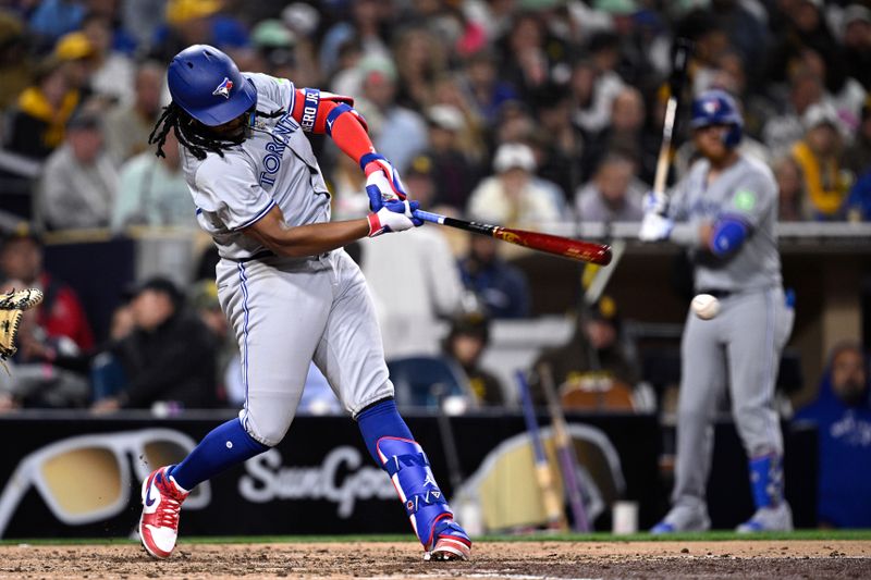 Apr 19, 2024; San Diego, California, USA; Toronto Blue Jays first baseman Vladimir Guerrero Jr. (27) hits a single against the San Diego Padres during the fifth inning at Petco Park. Mandatory Credit: Orlando Ramirez-USA TODAY Sports 