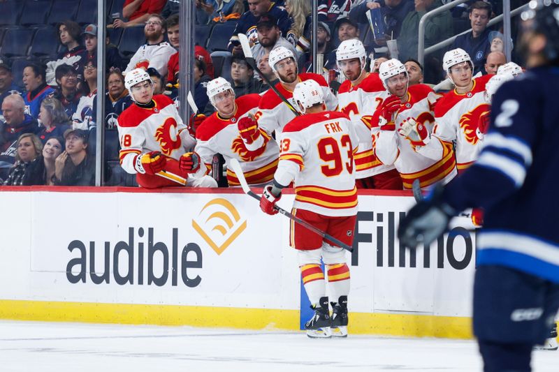 Oct 2, 2024; Winnipeg, Manitoba, CAN;  Calgary Flames forward Martin Frk (93) is congratulated by his teammates on his goal against the Winnipeg Jets during the first period at Canada Life Centre. Mandatory Credit: Terrence Lee-Imagn Images